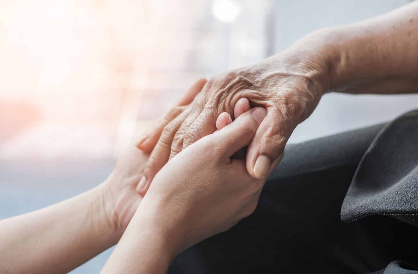 A loved one is holding their family member who struggles with memory loss in support for them.