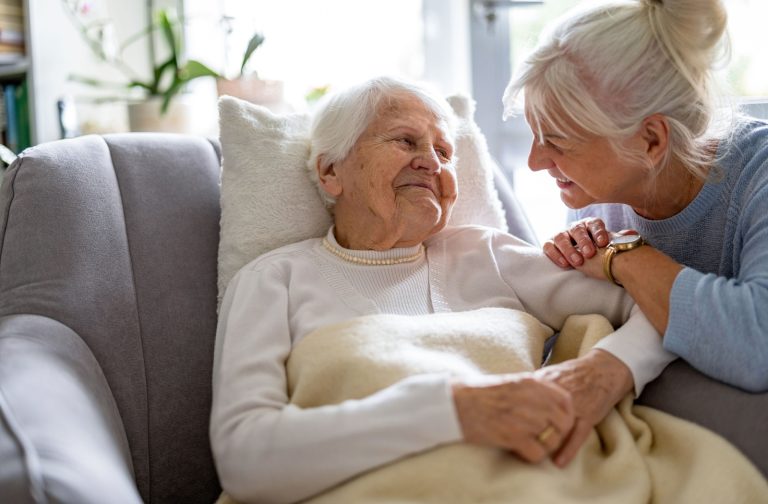 An older adult affectionately caring for their loved one with dementia.