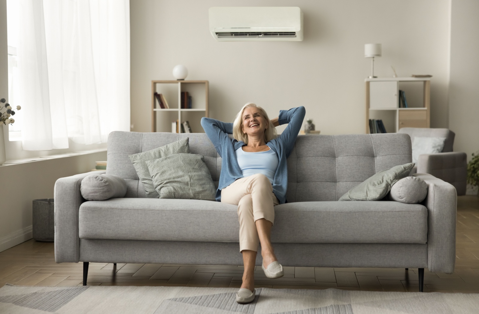 A senior relaxes on the couch, breathing in fresh air free of airborne contaminants and germs by a Negative Ion UV HVAC