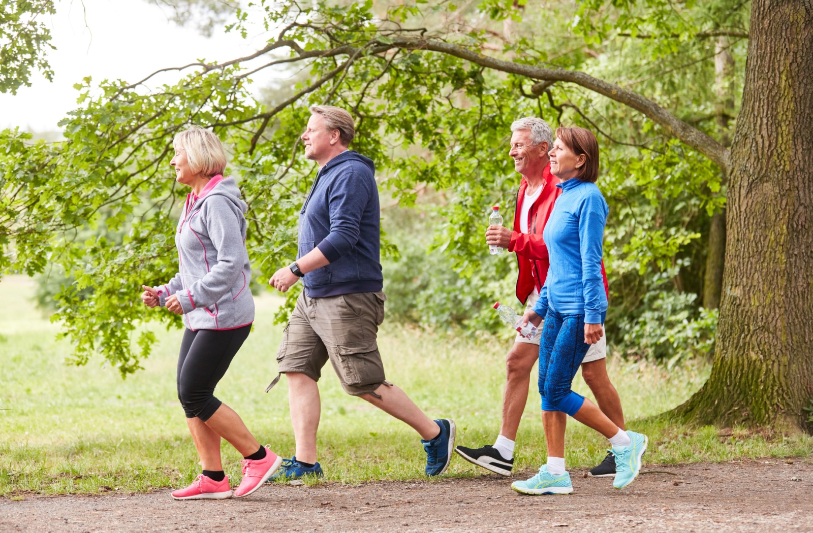 A group of active living residents enjoying an outdoor walk in the park.
