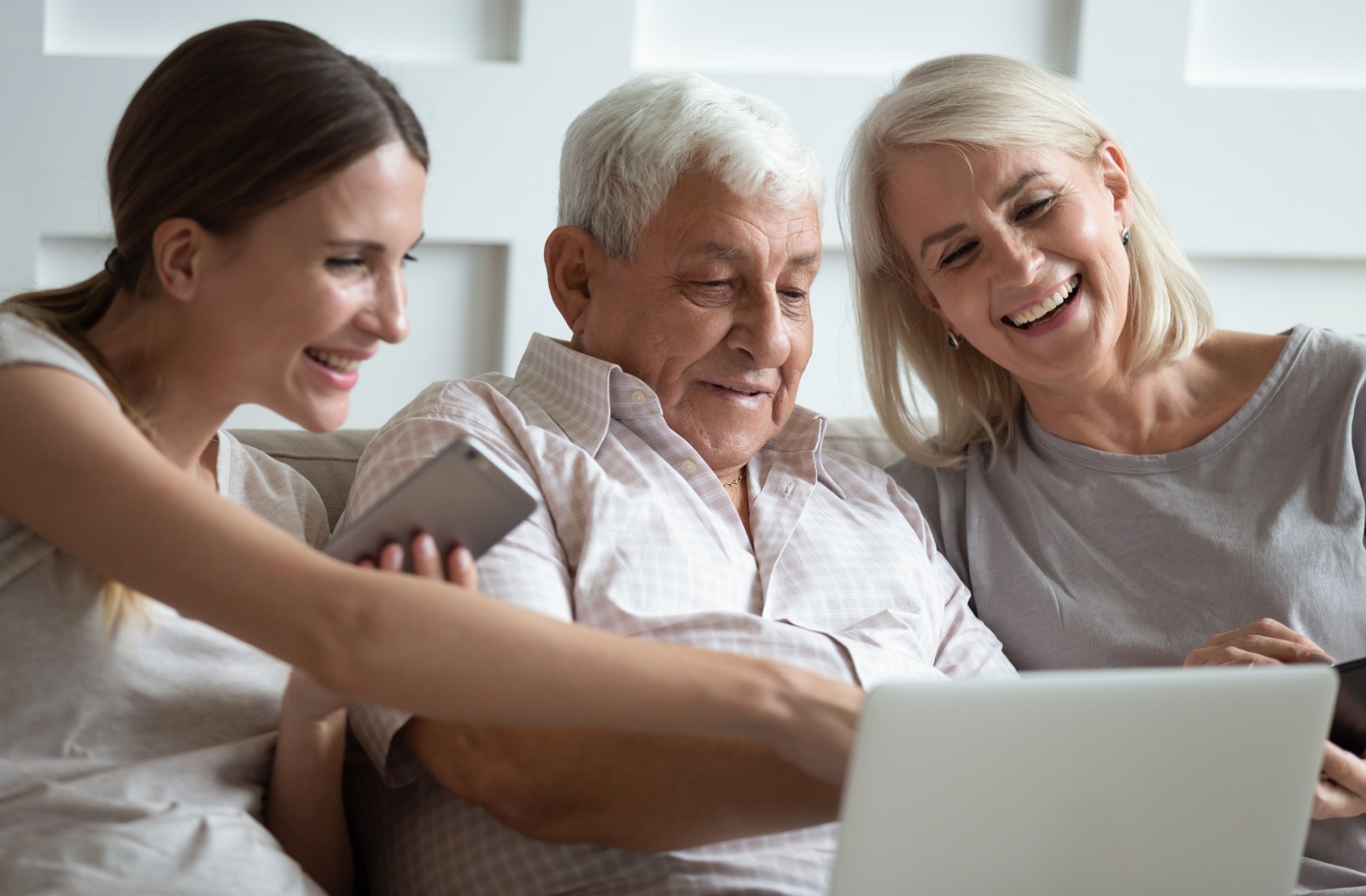 An adult child researches senior living options online with their mature parents.