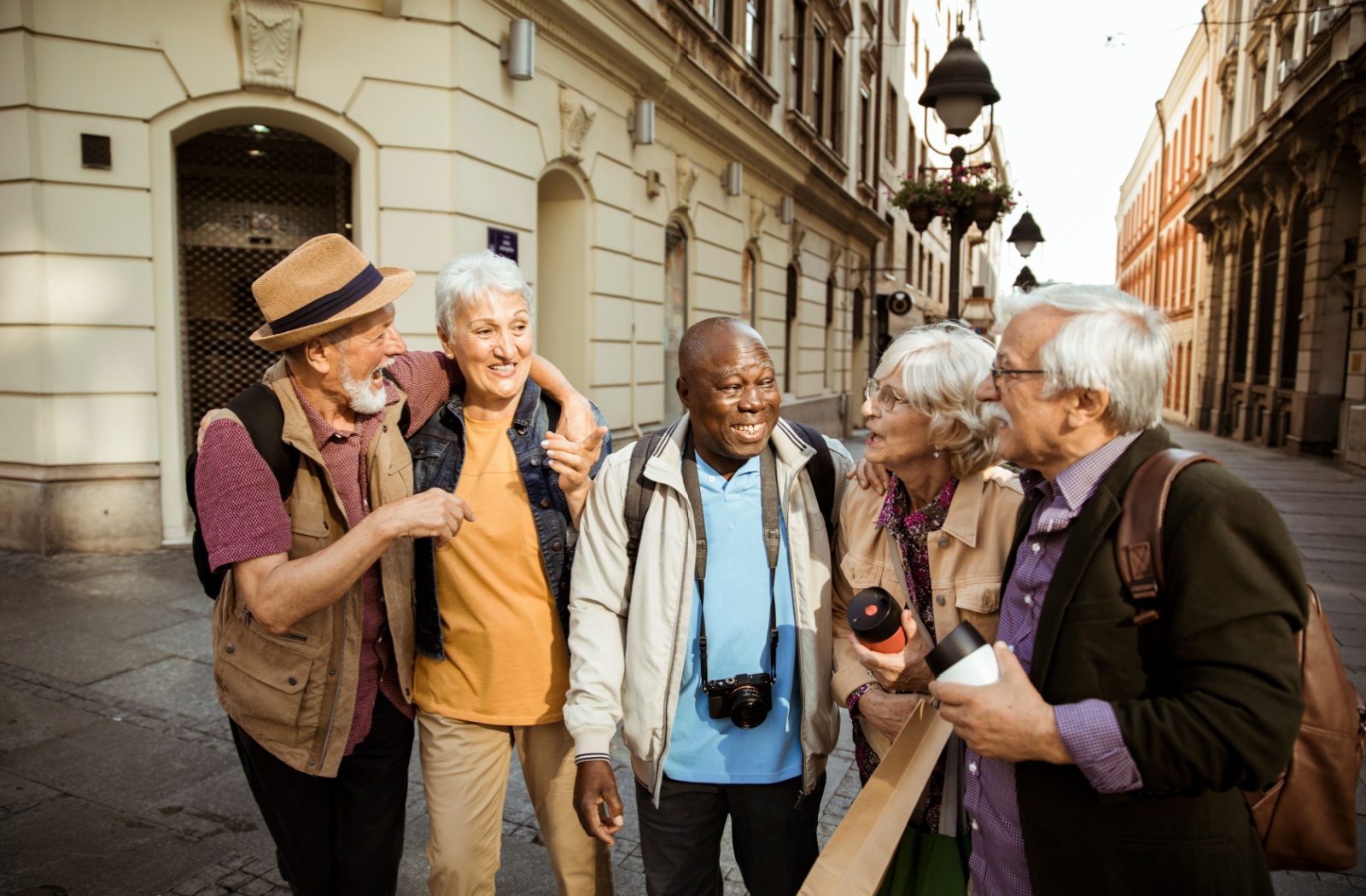 A group of seniors excitedly gather together while exploring a nearby city during a day travel trip