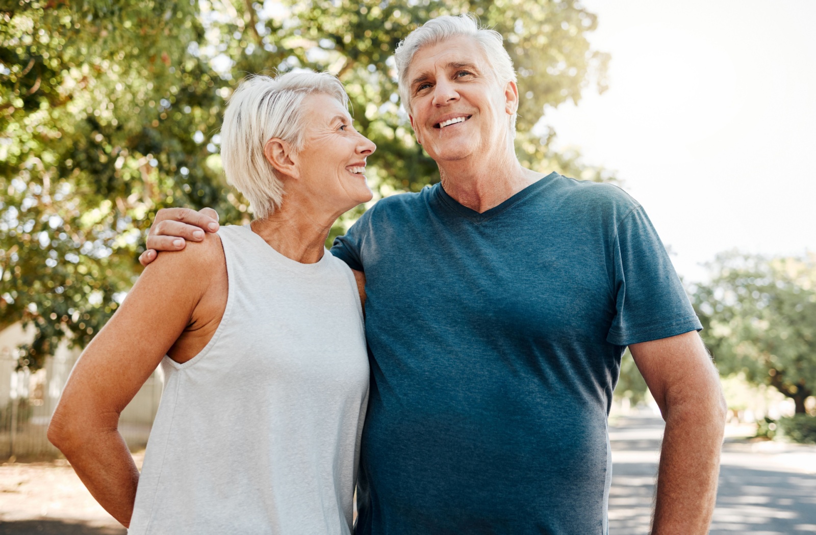 A senior couple smiles after walking for exercise in their senior living community.
