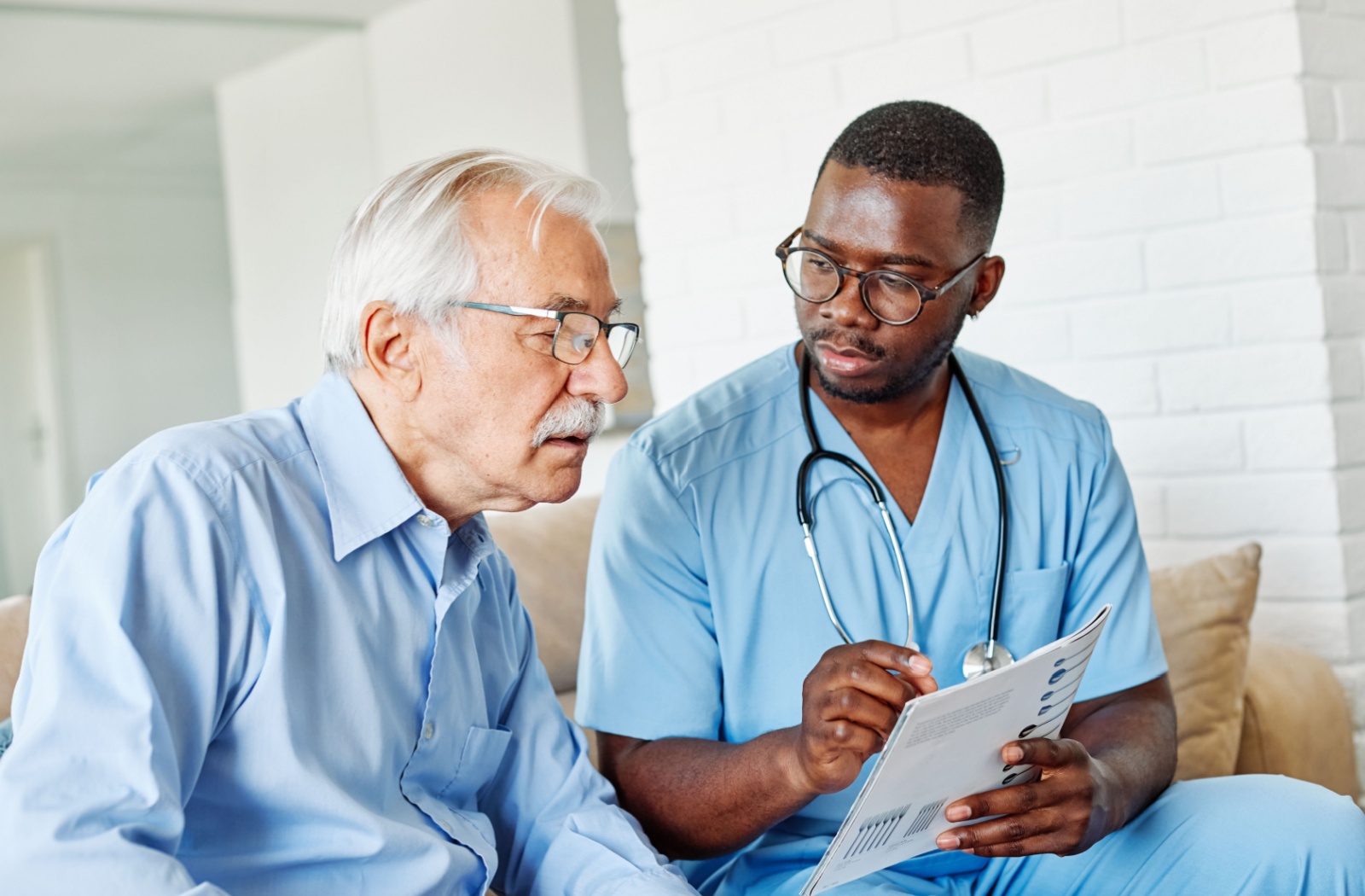 A nurse shows an older adult their printed forms after trying the FAST scale to diagnose their cognitive decline