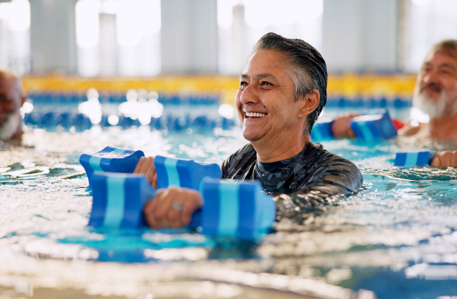 A senior resident enjoys a water aerobics class.